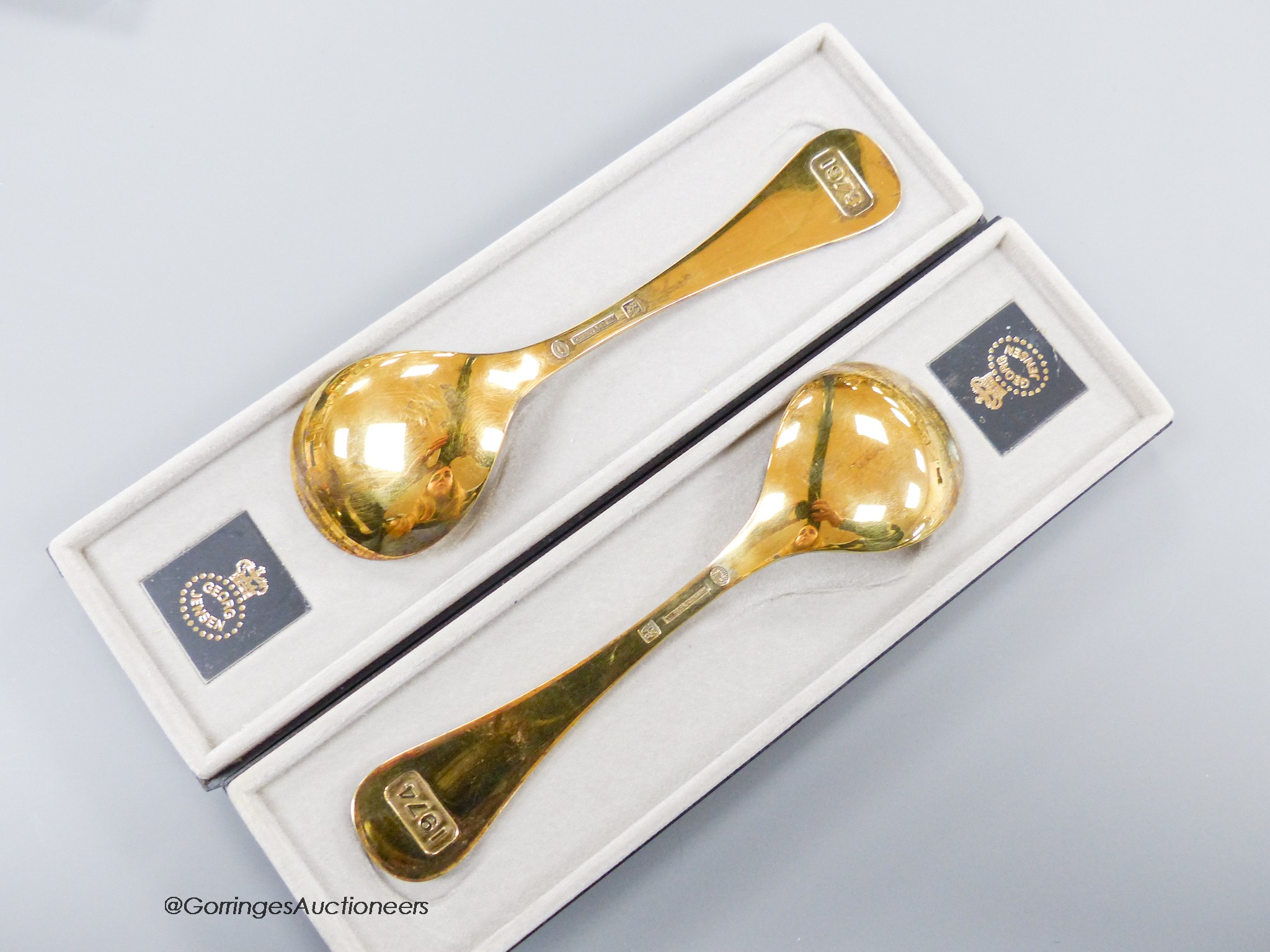 Two boxed Georg Jensen gilt sterling and enamel year spoons, 1973 & 1974 (Corn Marigold and Corn Cockle), 15cm, gross 91 grams.